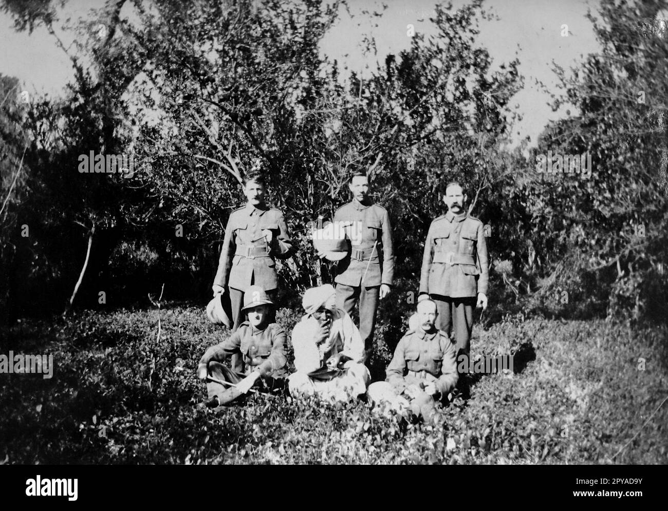 Eine Gruppe von R-Brigaden-Soldaten in einem Orangenhain in Amritsar, im indischen Staat Punjab. Eine Gruppe von sechs Soldaten, drei sitzend und drei stehend, auf einer Lichtung mit Bäumen im Hain dahinter. Dezember 1917. Von einem Schnappschuss aus dem Ersten Weltkrieg, der in Indien aufgenommen wurde. Stockfoto