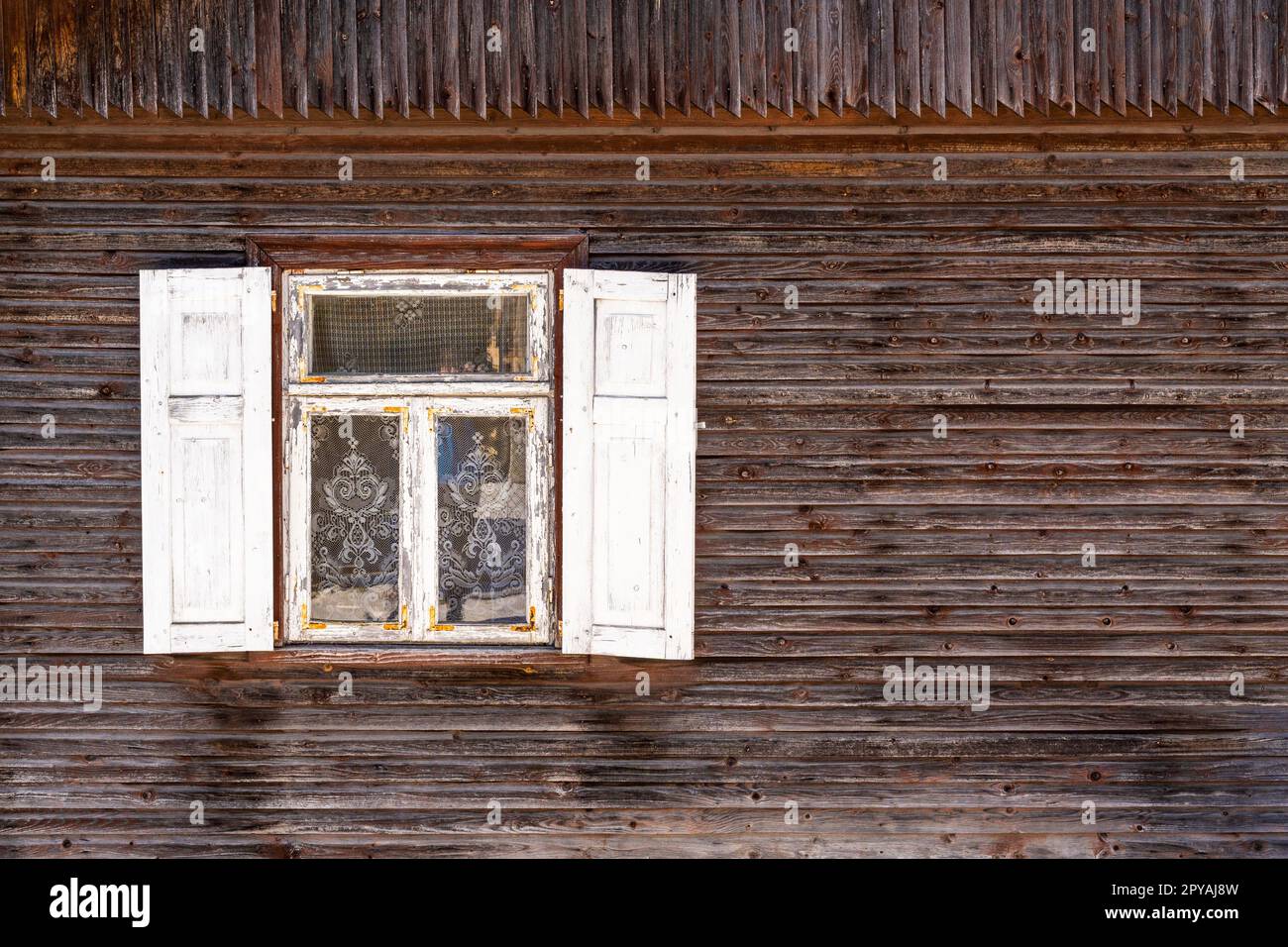 Altes Holzhaus, Fenster mit offenen weißen Fensterläden Stockfoto
