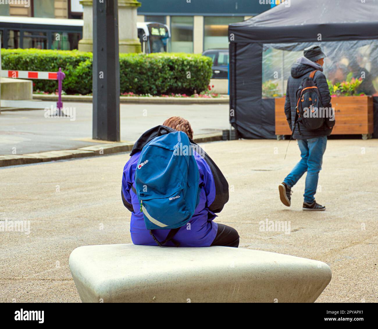 Tourist mit Rucksack sitzt und wartet auf dem george Square Stockfoto