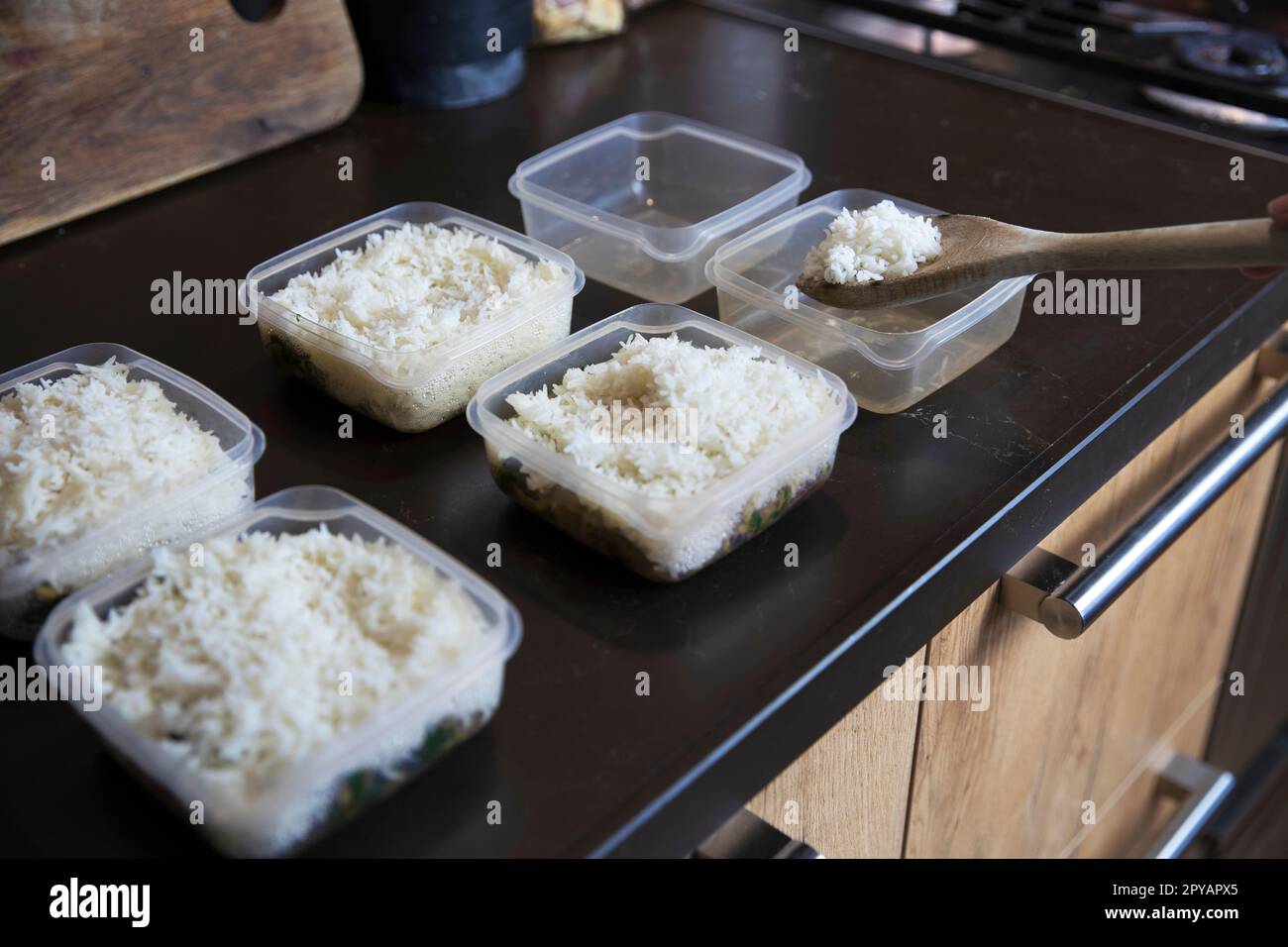 Speisezubereitung Stapel hausgemachter Reis- und Hühnergerichte in Behältern, die zum Einfrieren bereit sind, um sie später als schnelle und einfache Fertiggerichte zu verwenden. Nahrungsvorbereitung für eine gesunde Ernährung Stockfoto