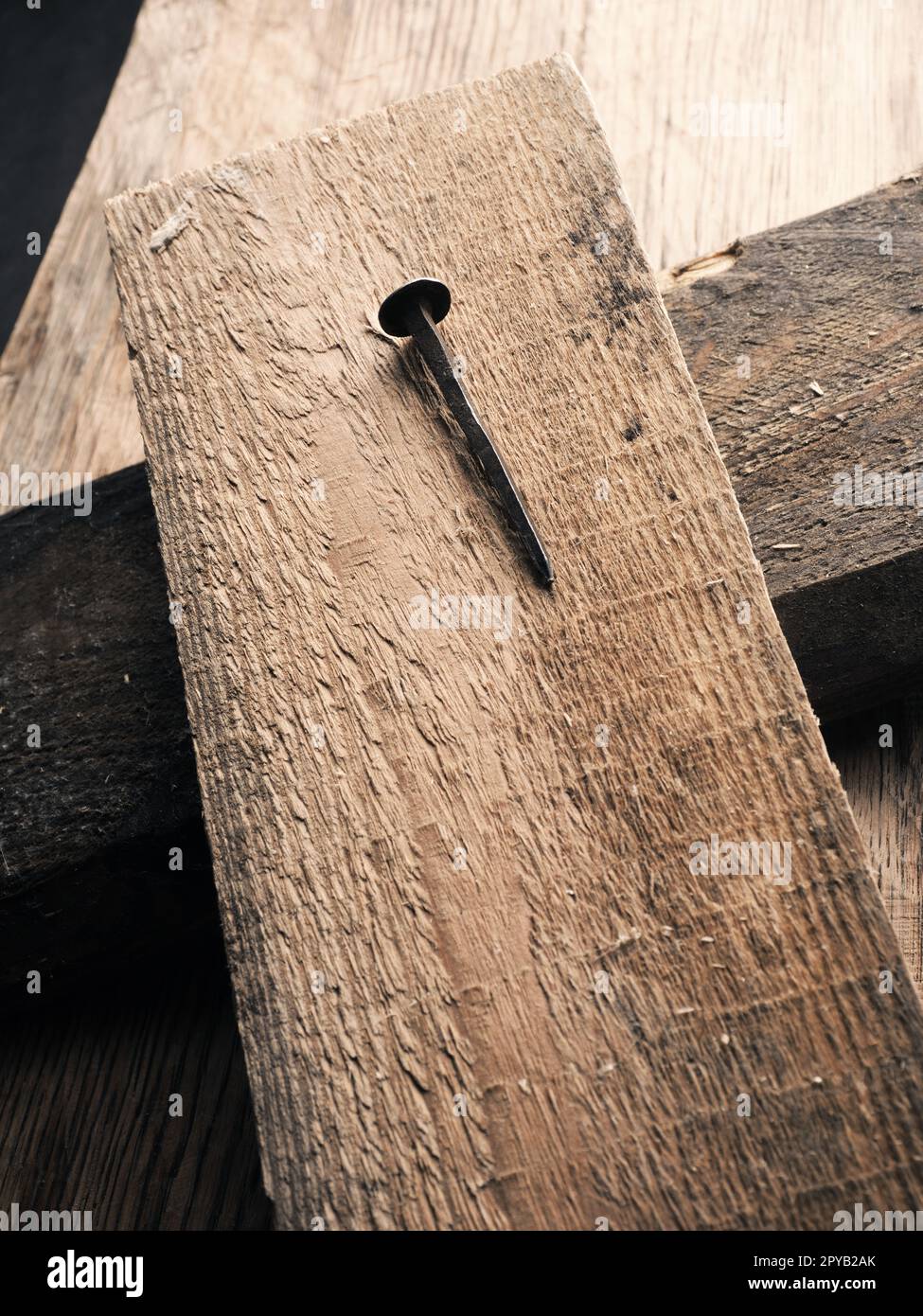 Ein Holzkreuz mit einem alten rostigen Nagel symbolisiert die Kreuzigung Jesu. Osterkonzept Stockfoto