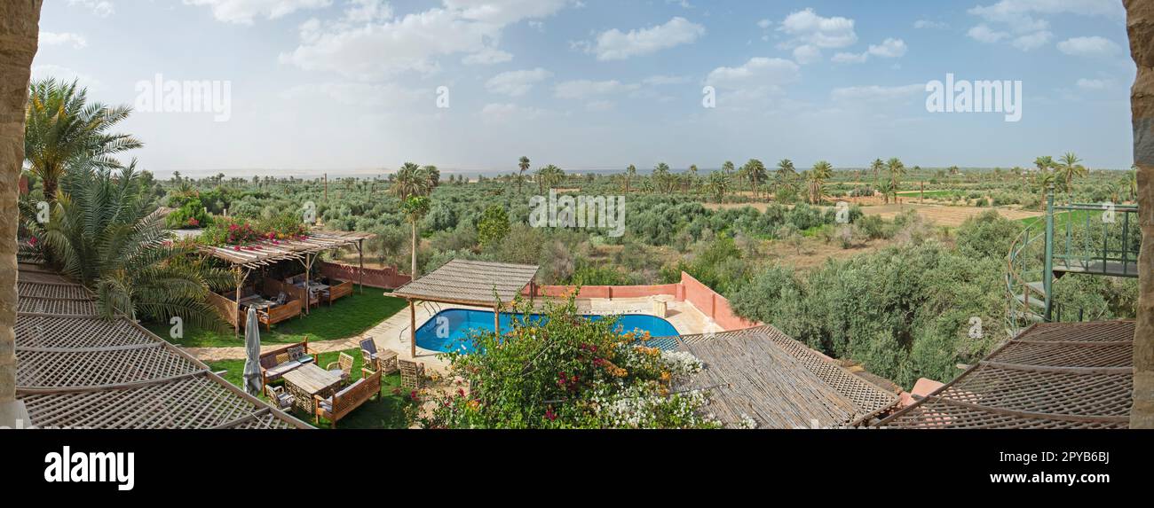 Panoramablick auf abgelegene afrikanische ägyptische Ackerland mit Swimmingpool im Vordergrund und See im Hintergrund Stockfoto