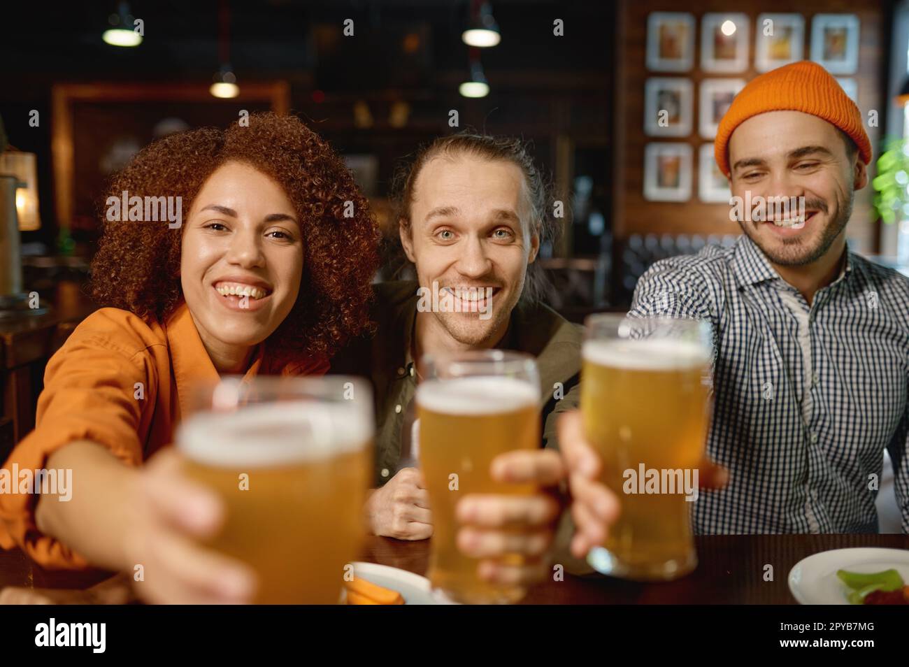 Eine Gruppe junger Leute, die vor der Kamera lächeln und mit Brille klappern Stockfoto