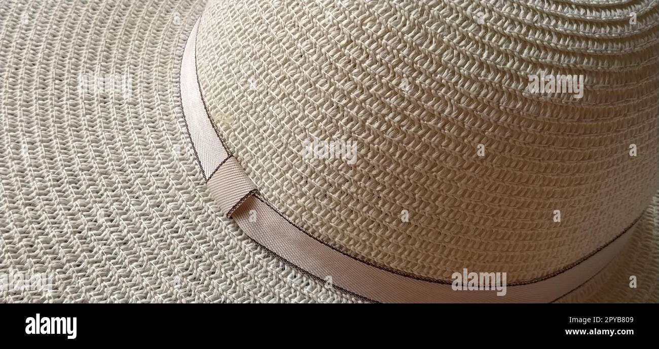 Hutband. Ein Gurt oder eine Verzierung auf dem Kopfschmuck. Strohhut-Nahaufnahme. Reise- und Freizeitthema. Sommerferien. Blick von oben. Stockfoto