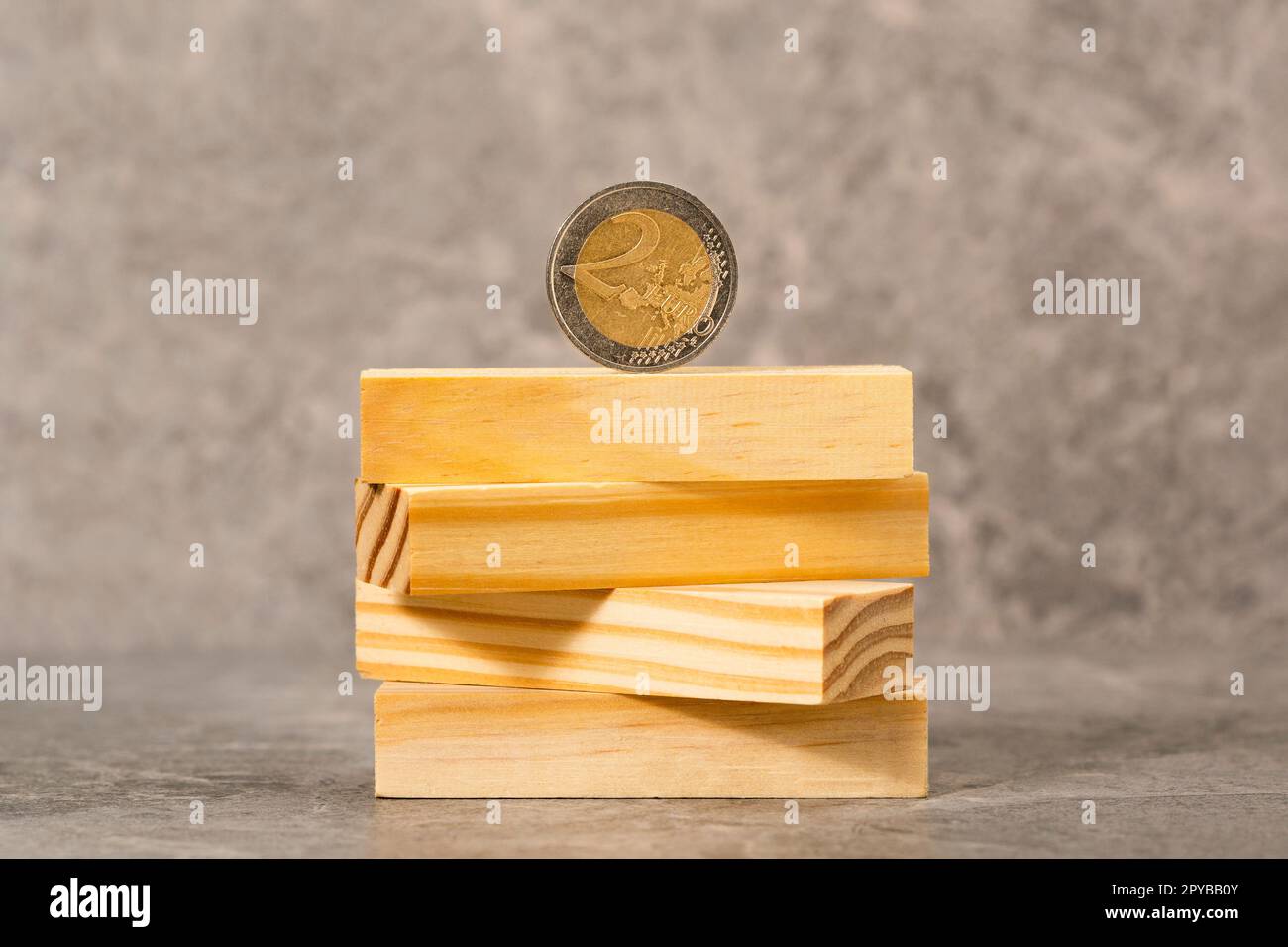 Zwei Euro-Münzen balancieren auf einem Holzblock-Turm Stockfoto