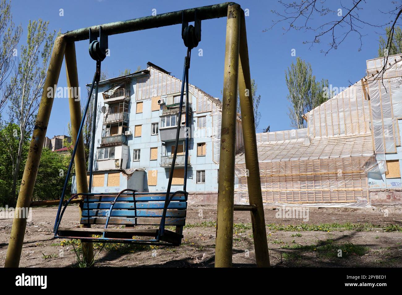 Eine Kinderschaukel, die vom erhaltenen Wohnungsgebäude für den Wiederaufbau gesehen wurde, das durch die russischen Bomben schwer beschädigt wurde. Natalia Humeniuk, Leiterin des Gemeinsamen Pressezentrums für das operative Kommando Pivden (Süden), hat erklärt, dass die Verschärfung der russischen Bombardierungen im Süden der Ukraine damit zusammenhängt, dass die russischen Besatzer keine Siege errungen haben. Sie fügte hinzu, dass die russischen Streitkräfte die Verteidigung in den vorübergehend besetzten Gebieten im Süden planen. Humeniuk sagt, dass die Eindringlinge Verteidigungslinien bauen und die technischen Anlagen in diesen Anlagen verbessern Stockfoto