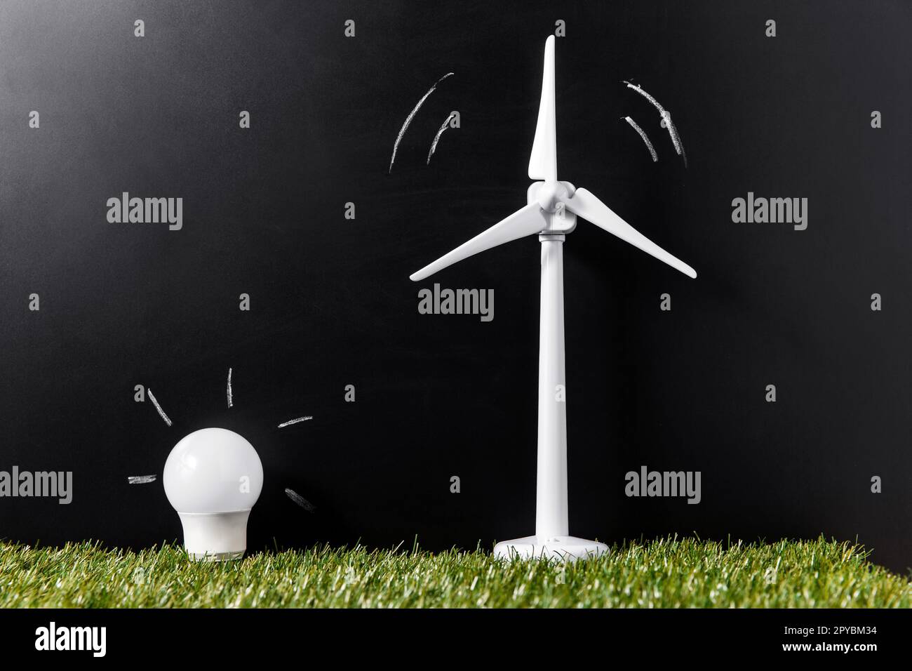Nahaufnahme von Windturbine und Glühbirne auf Gras Stockfoto