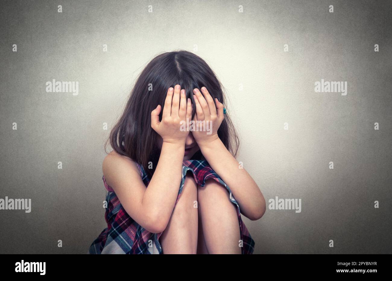 Kleines Mädchen, das in Depressionen sitzt Stockfoto