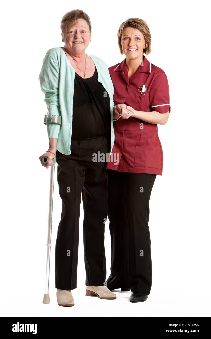 Fachkräfte Im Gesundheitswesen: Rehabilitation. Eine ältere Patientin, der von einer freundlichen Krankenschwester wieder auf die Füße geholfen wird. Aus einer Reihe von zugehörigen Bildern. Stockfoto