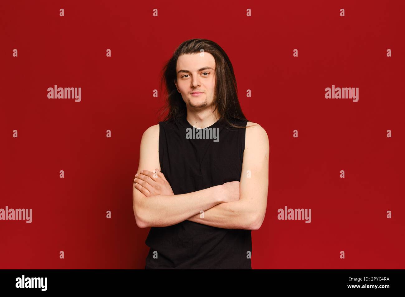 Studioporträt eines jungen, gutaussehenden Mannes mit langen schwarzen Haaren Stockfoto