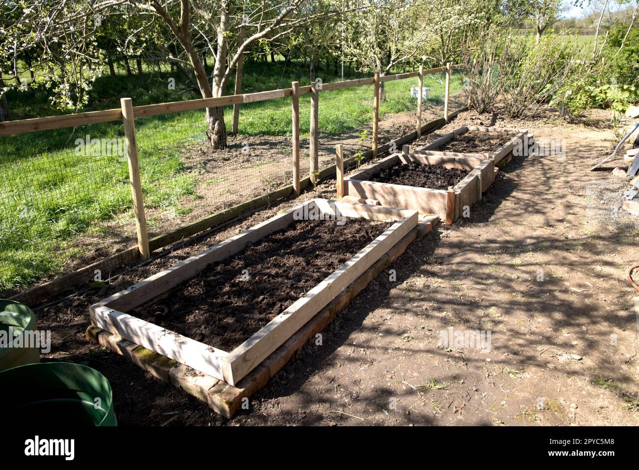 Neu gebaute erhöhte Gemüseböden aus Schrottholz, das beim Hausabbruch übrig geblieben ist Stockfoto