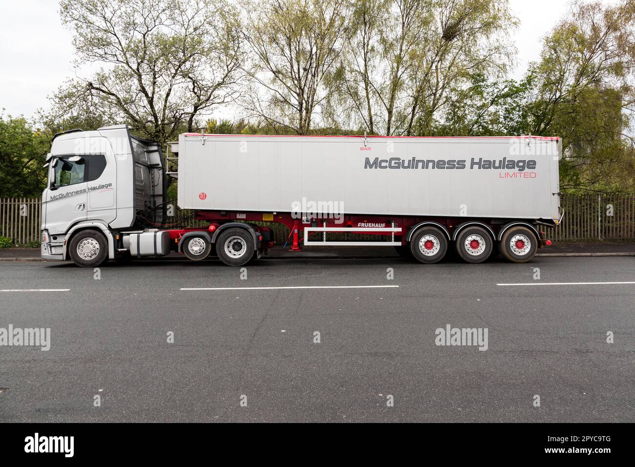 Ein knickgelenkter Muldenkipper von McGuinness, der am Straßenrand in Glasgow, Schottland, Großbritannien und Europa geparkt ist Stockfoto