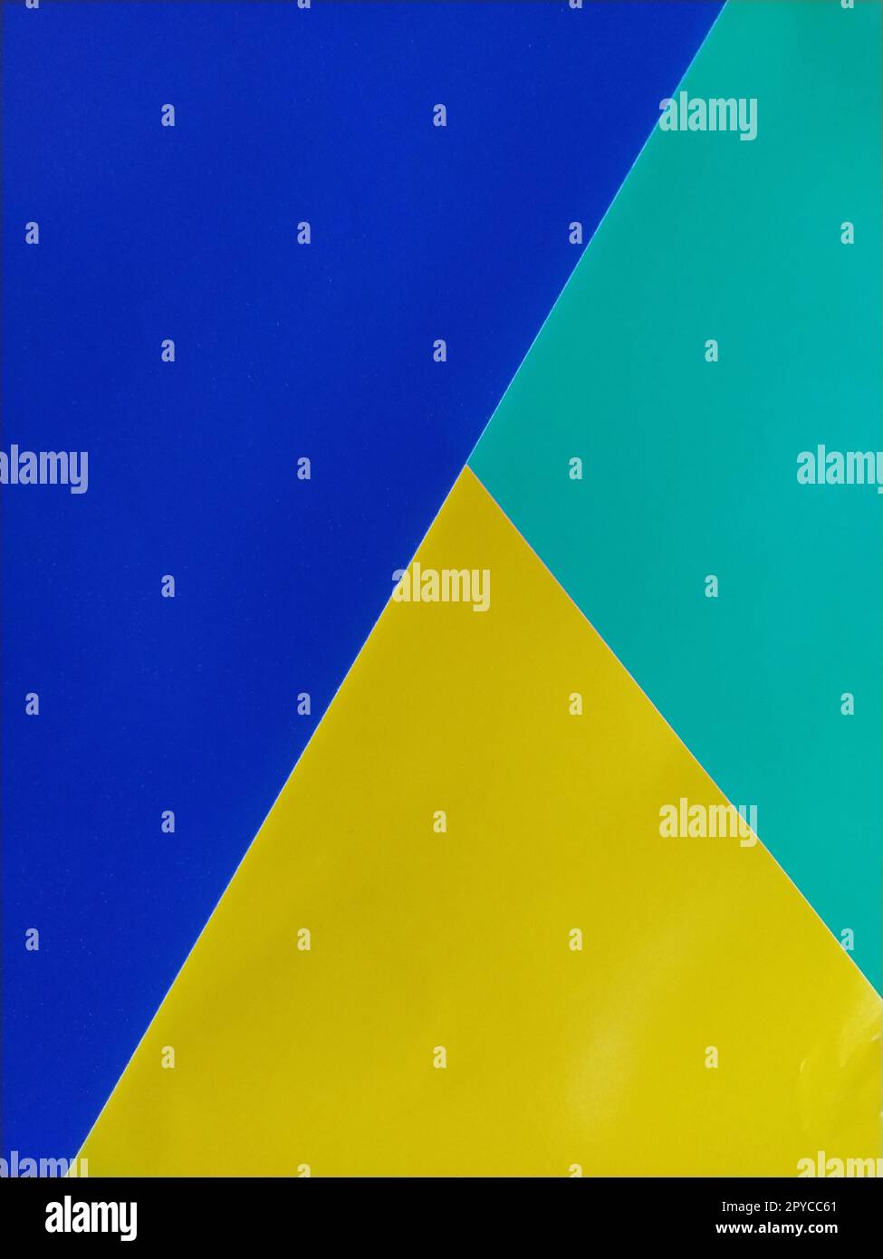 Blaues, grünes und gelbes Papier übereinander gestapelt. Farbenfroher Hintergrund Stockfoto
