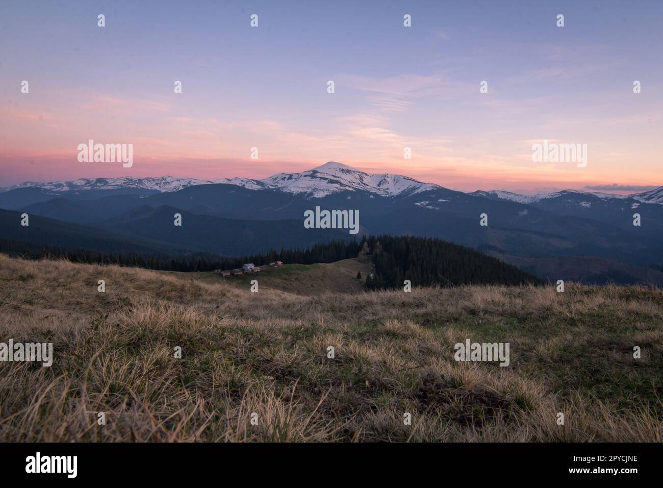 Pastellfarbener Sonnenuntergang über dem verschneiten Berggipfel, Landschaftsfoto Stockfoto