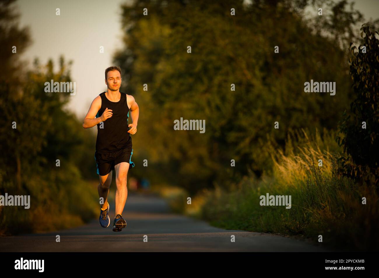 Schoß eines jungen männlichen Athleten Training auf der Rennstrecke. Sprinter läuft auf Athletik Titel von oben gesehen. Stockfoto
