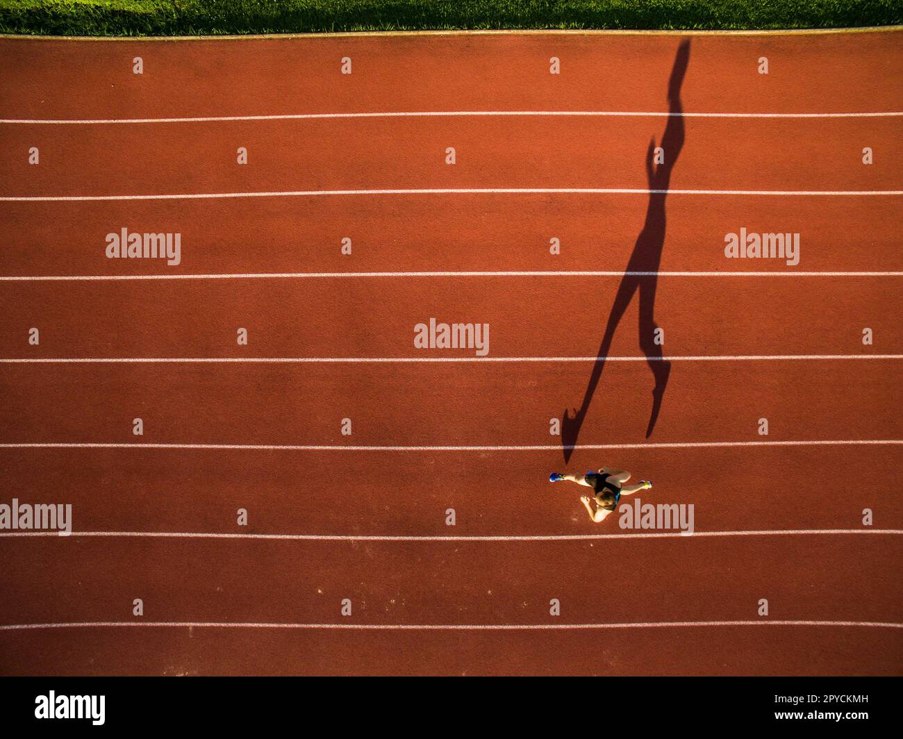 Schoß eines jungen männlichen Athleten Training auf der Rennstrecke. Sprinter läuft auf Athletik Titel von oben gesehen. Stockfoto