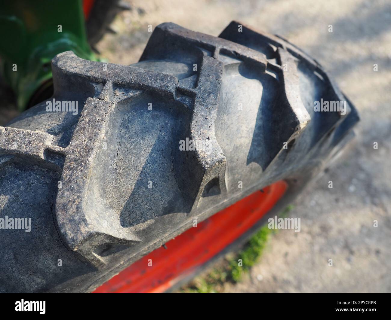 Reifen von einem Motorgrubber. Nahaufnahme eines Rades von einem kleinen Landwirtschaftstraktor. Gummigewinde. Industriedetails. Stockfoto