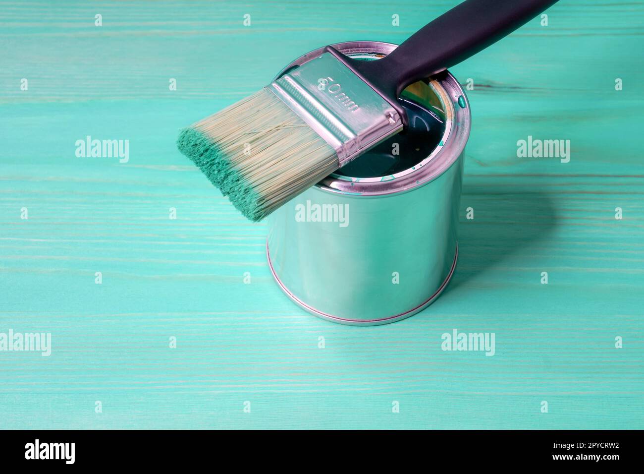 Pinsel mit der grünen Farbe liebt auf der Farbkann Stockfoto