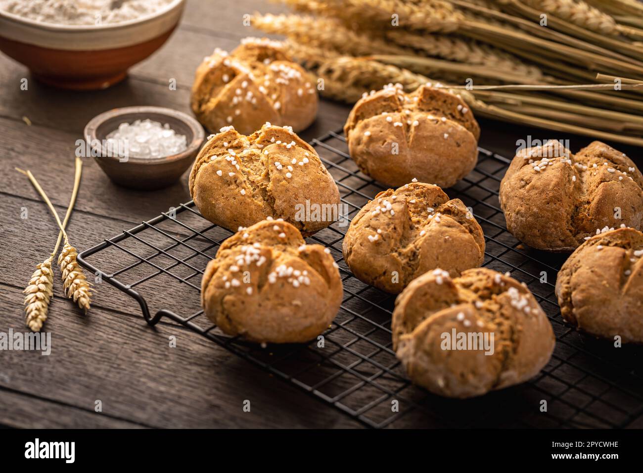 Hausgemachte Spelzbrötchen mit Salz auf Holzhintergrund Stockfoto