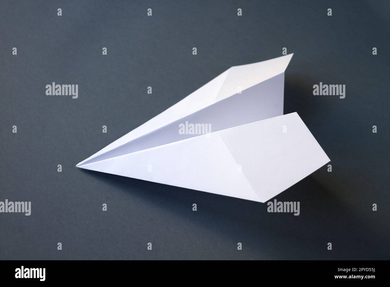 Weißpapierflugzeug Origami isoliert auf grauem Hintergrund Stockfoto