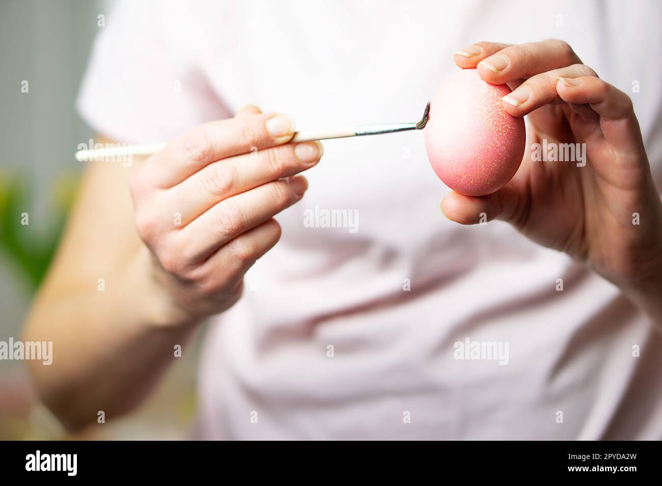 Nahaufnahme von weiblichen Händen mit Osterei und Malerei mit einem Pinsel. Vorbereitung für Ostern. Stockfoto