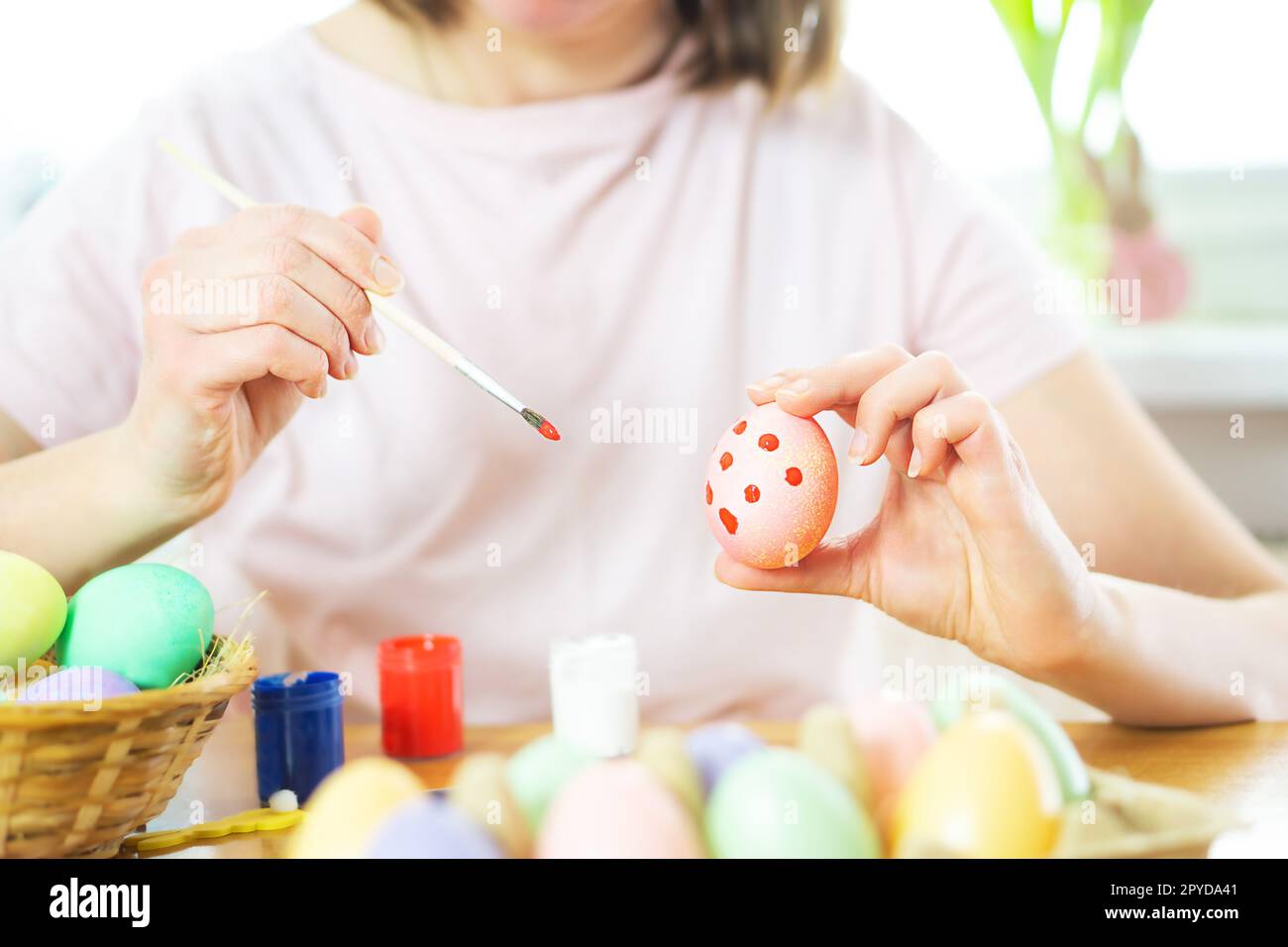 Nahaufnahme von weiblichen Händen mit Osterei und Malerei mit einem Pinsel. Vorbereitung auf Ostern. Stockfoto