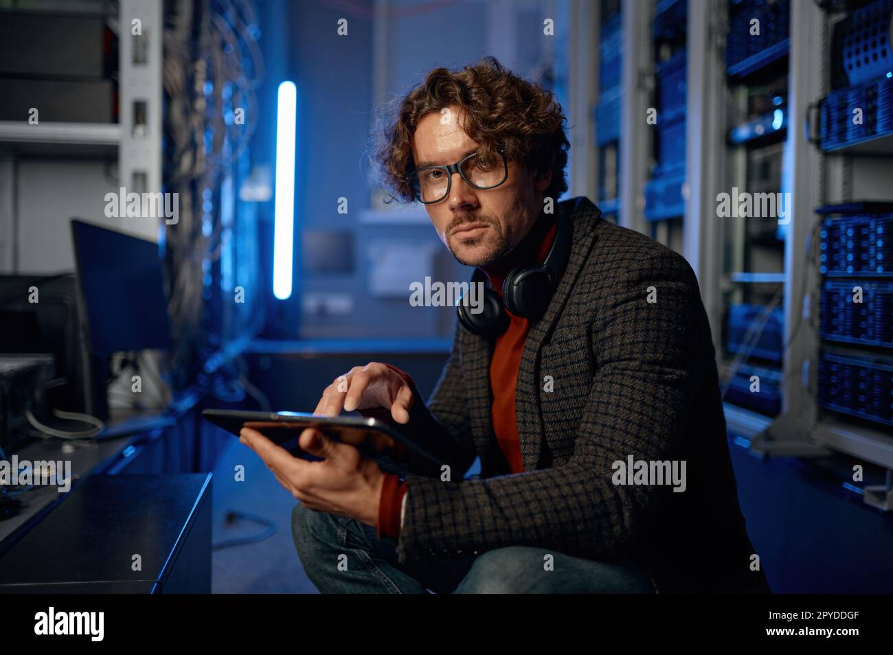 Männlicher IT-Techniker, der im Serverraum mit einem Tablet arbeitet Stockfoto