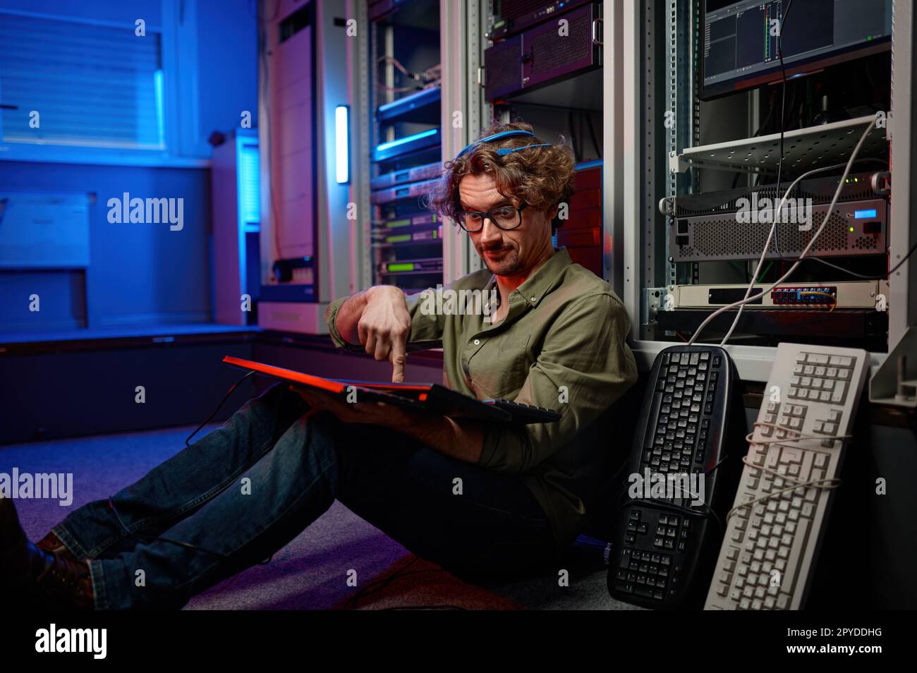 Überarbeiteter Rechenzentrumsingenieur, der die Tastatur im Serverraum eines Supercomputers verwendet Stockfoto