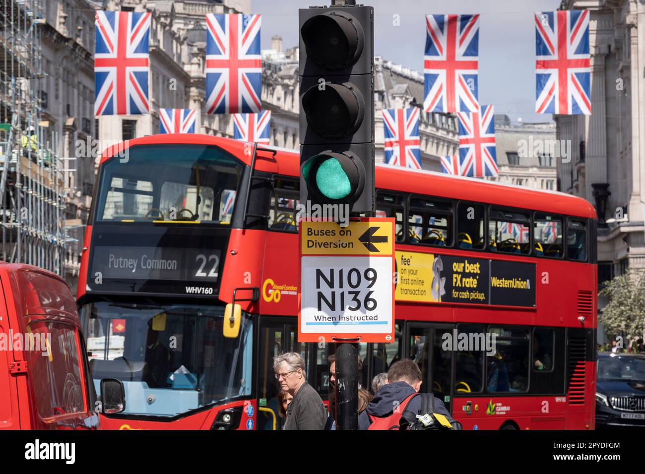 Nur vier Tage vor der Krönung von König Karl III., nach dem Tod seiner Mutter, Königin Elzabeth II. Im vergangenen Jahr, hängen die Flaggen von Union Jack über einem Bus und einem Verkehrsablenkungsschild auf der Regent Street, am 3. Mai 2023, in London, England. Stockfoto