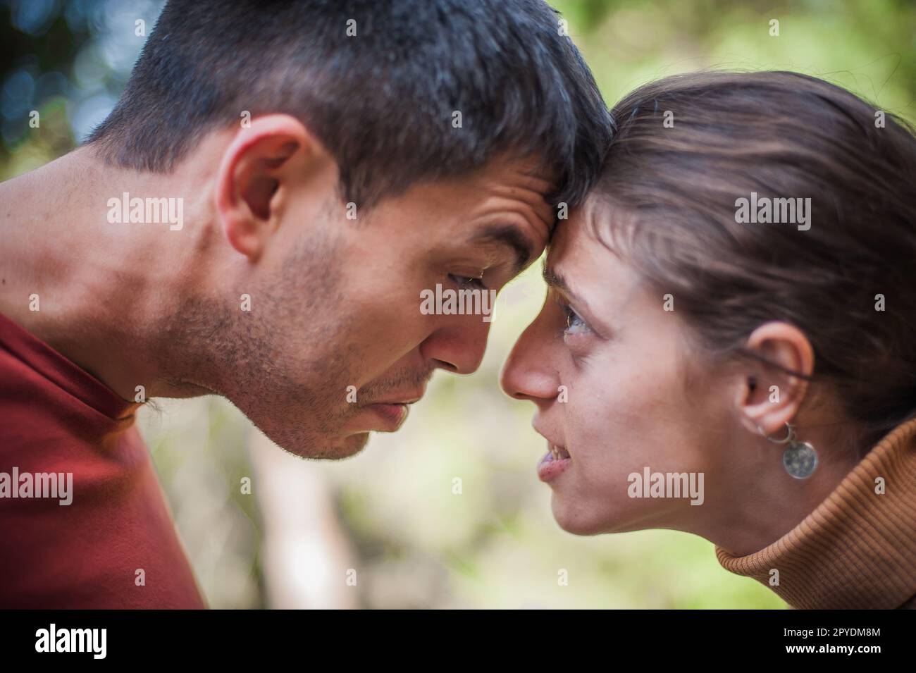 Kopf an Kopf. Ein wütendes Paar, ein Mann und ein Mädchen, drängen sich gegenseitig. Beziehungsprobleme Stockfoto