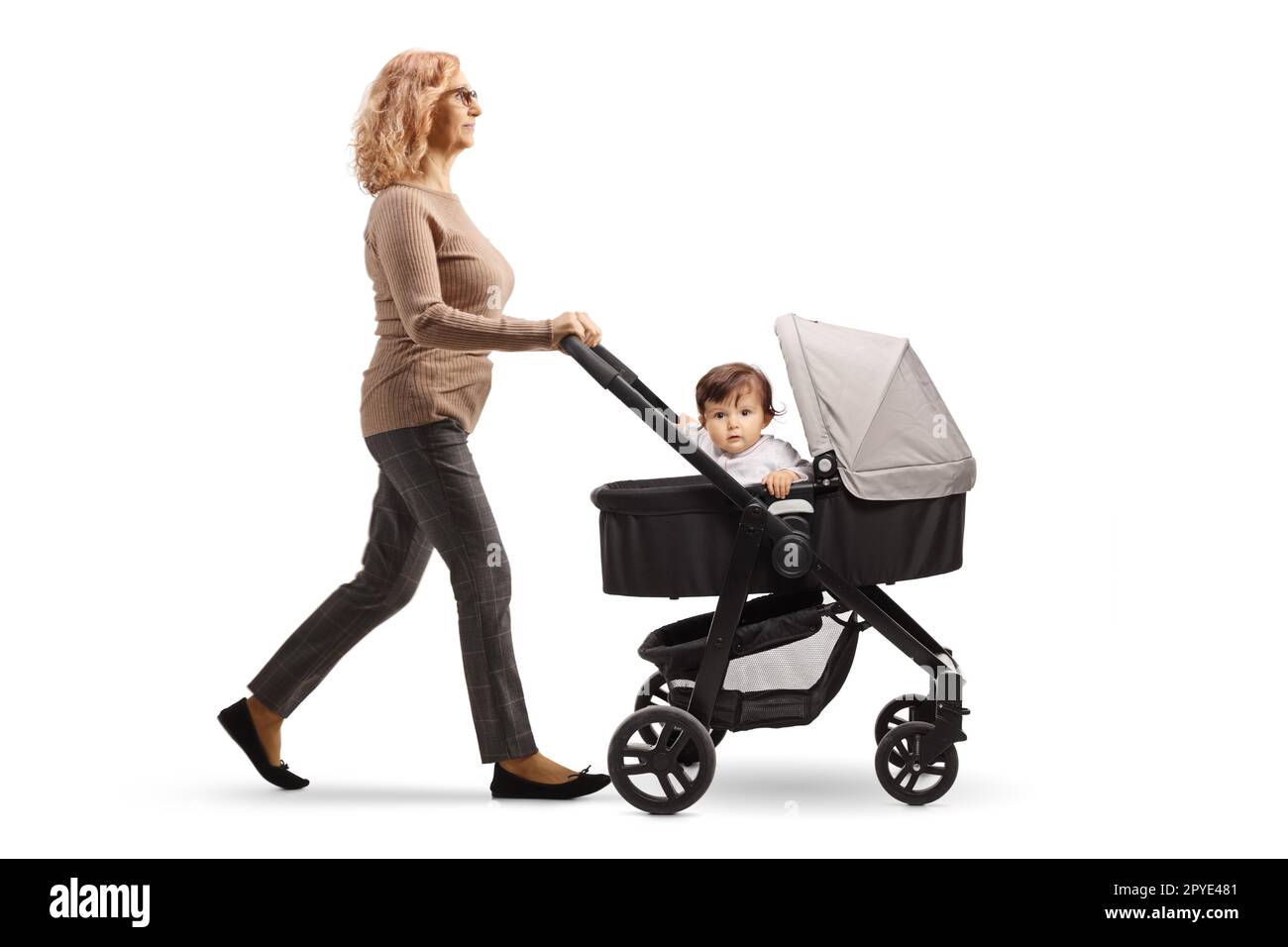 Profilaufnahme über die gesamte Länge einer erwachsenen Frau, die ein Baby in einem Buggy schubst, isoliert auf weißem Hintergrund Stockfoto