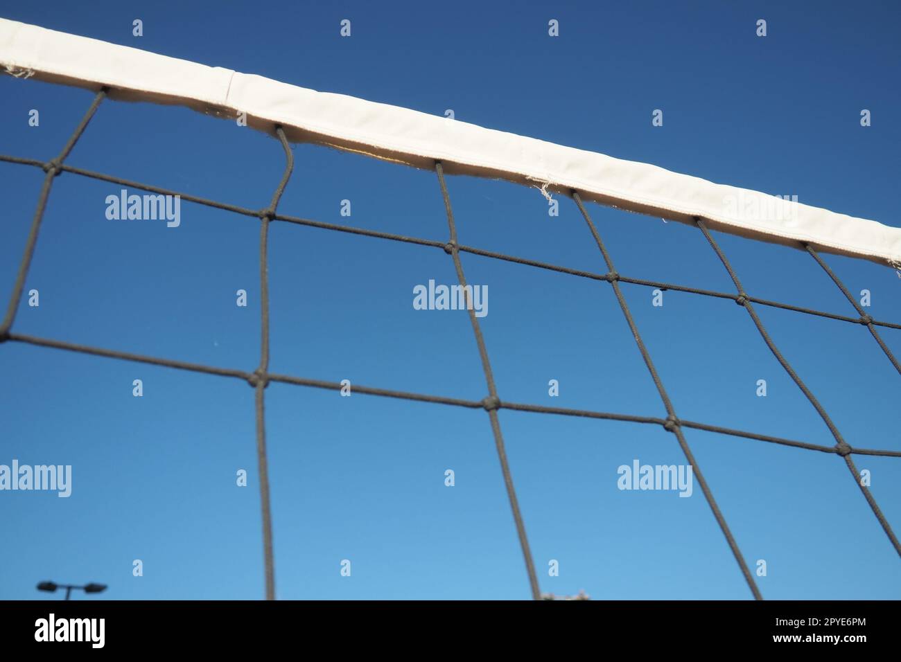 Volleyballsport, das Netz gegen die Nahaufnahme des blauen Himmels aufteilt. Outdoor-Sport Stockfoto