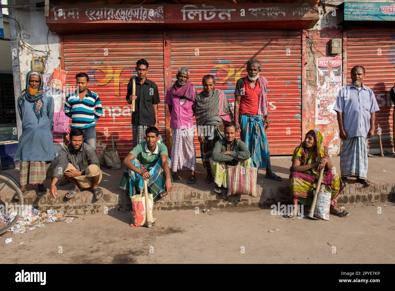 Bangladesch, Jhenaidah. Tagarbeiter mit ihren Werkzeugen, Männer und Frauen, die auf der Suche nach Arbeit am Straßenrand stehen. 20. März 2017. Editorial Stockfoto