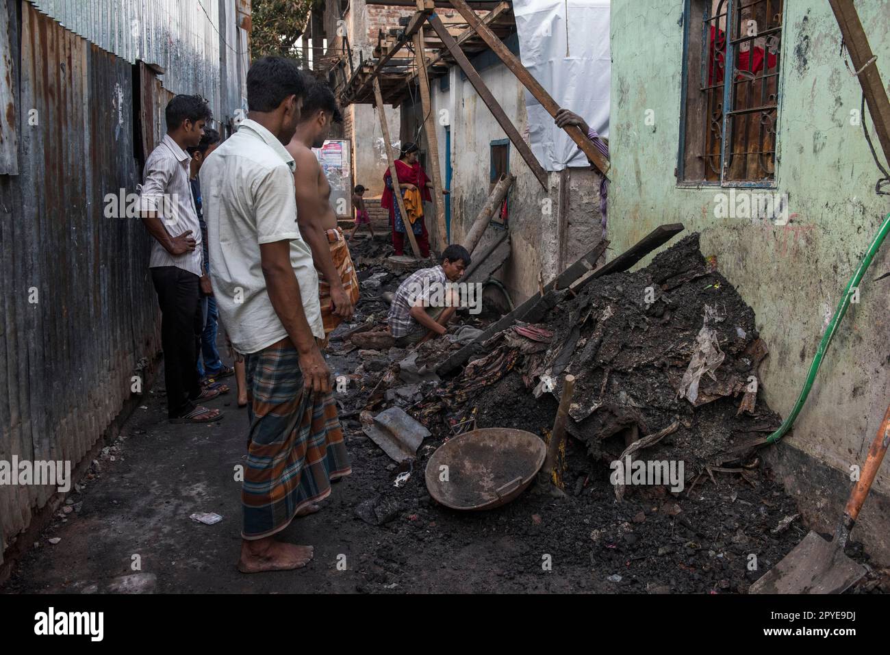 Bangladesch, Dhaka, Korail. Männer machen eine Bestandsaufnahme der Reste eines kürzlichen Feuers. 27. März 2017. Nur redaktionelle Verwendung. Stockfoto