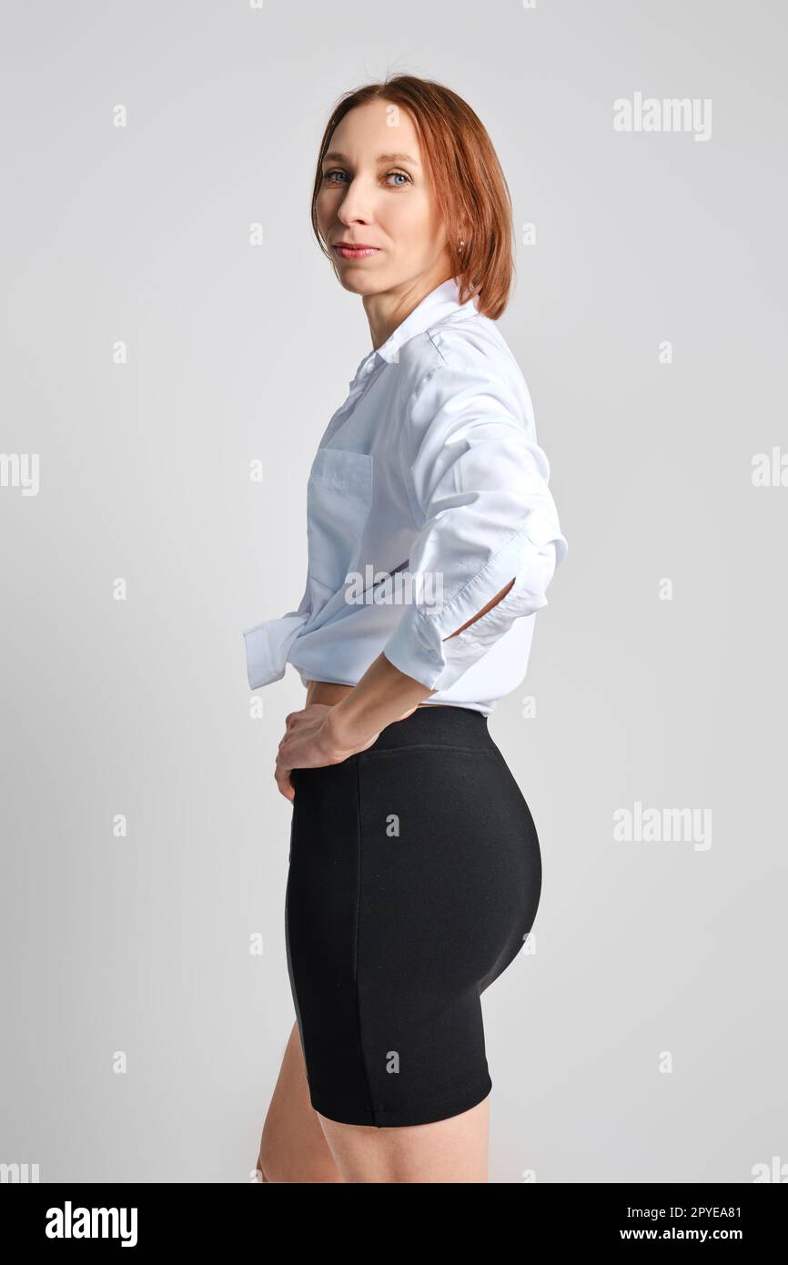 Porträt einer erwachsenen Frau im engen Minirock und weißen Hemd Stockfoto