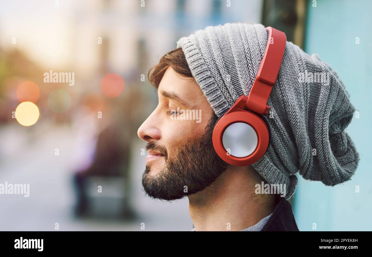 Keine Worte nötig, nur Musik. Ein junger Mann, der in der Stadt Musik hört. Stockfoto