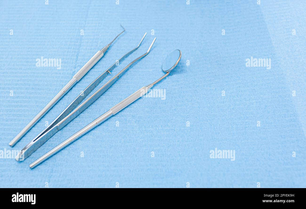 Zahnarztwerkzeuge auf hellblauem Hintergrund Stockfoto