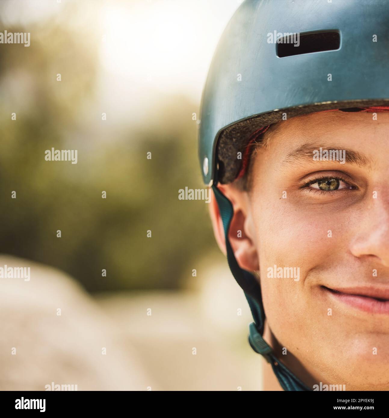 Nahaufnahme Porträt, Radhelm und Lächeln für einen Mann im Mountain Bike Park, Wettbewerb oder Wettbewerb. Fröhliche Radfahrerin, Gesichtszoom und Sicherheit beim Radrennen, Extremsport und Fokus auf die Vision für den Sieg Stockfoto