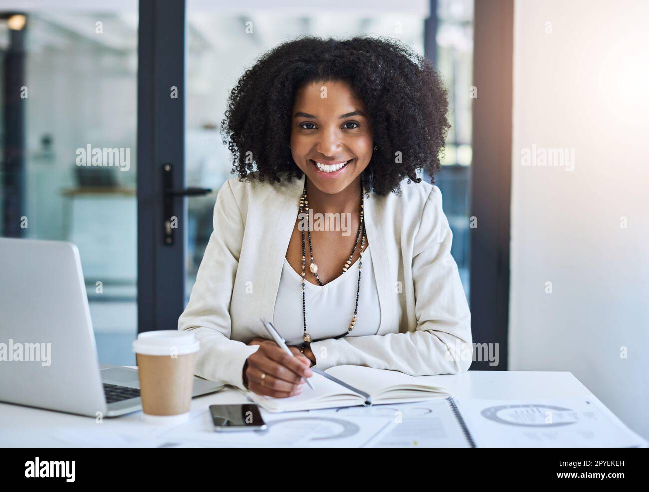 Immer bereit, die Zukunft mit dir umzuschreiben. Porträt einer jungen Geschäftsfrau, die am Schreibtisch lächelt und gut gelaunt ist. Stockfoto