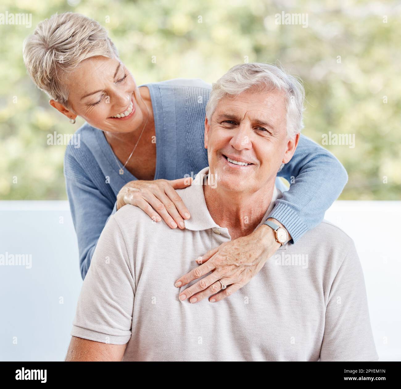 Ein glückliches Seniorenpaar umarmt sich zu Hause, im Haus und in der Wohnung, während es sich in der Lounge für Liebe, Pflege und Ruhestand zusammen in Australien erholt. Glück, Lächeln und alter Mann, Frau und Menschen genießen eine schöne Zeit Stockfoto