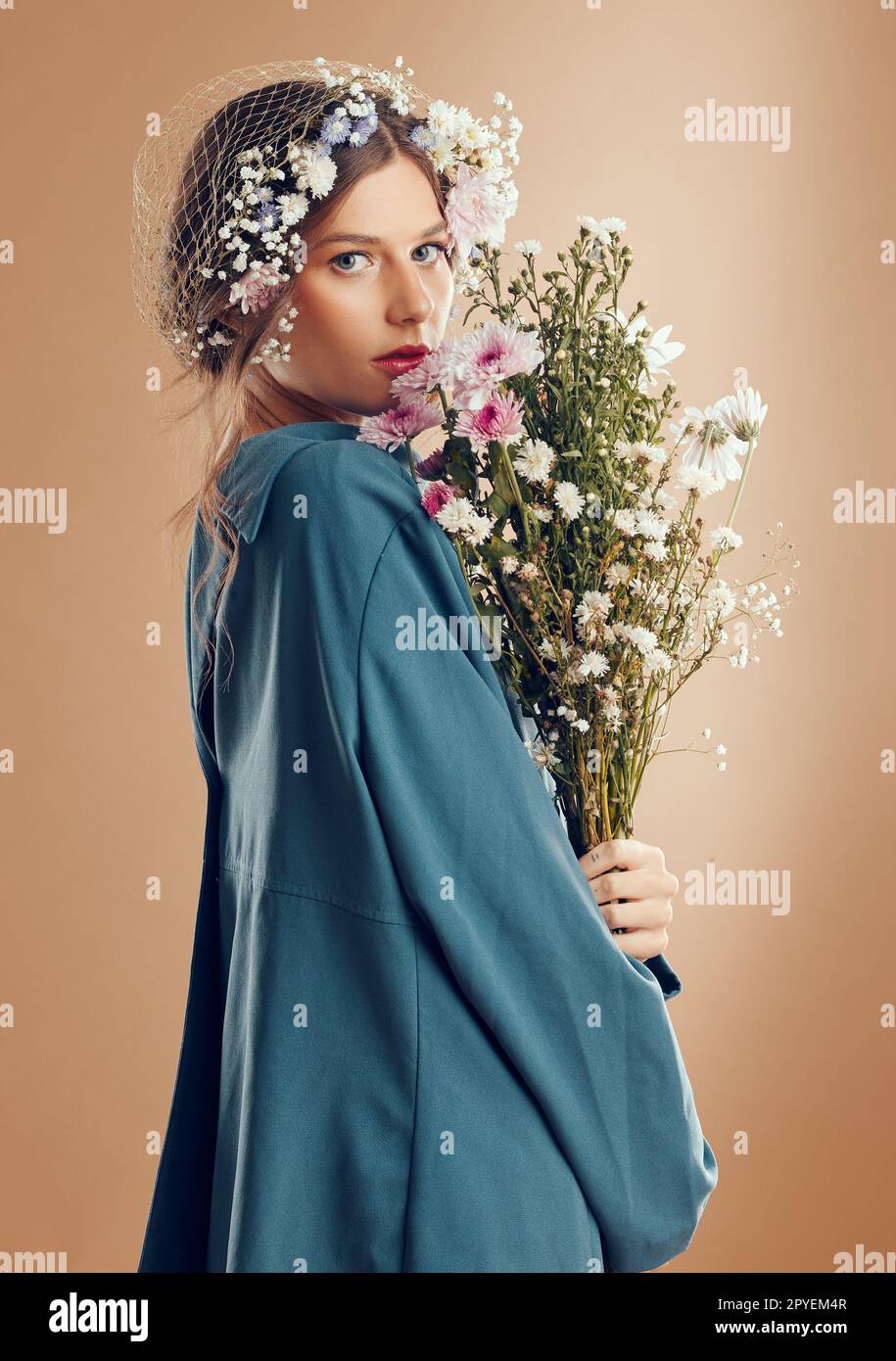 Ästhetische Frau, Schönheit und Blumen im Studiohintergrund für Kosmetik, Hautpflege und Dermatologie im Frühling in der Amish-Kultur. Porträt eines weiblichen Modells mit Blume für natürlichen Modestil Stockfoto