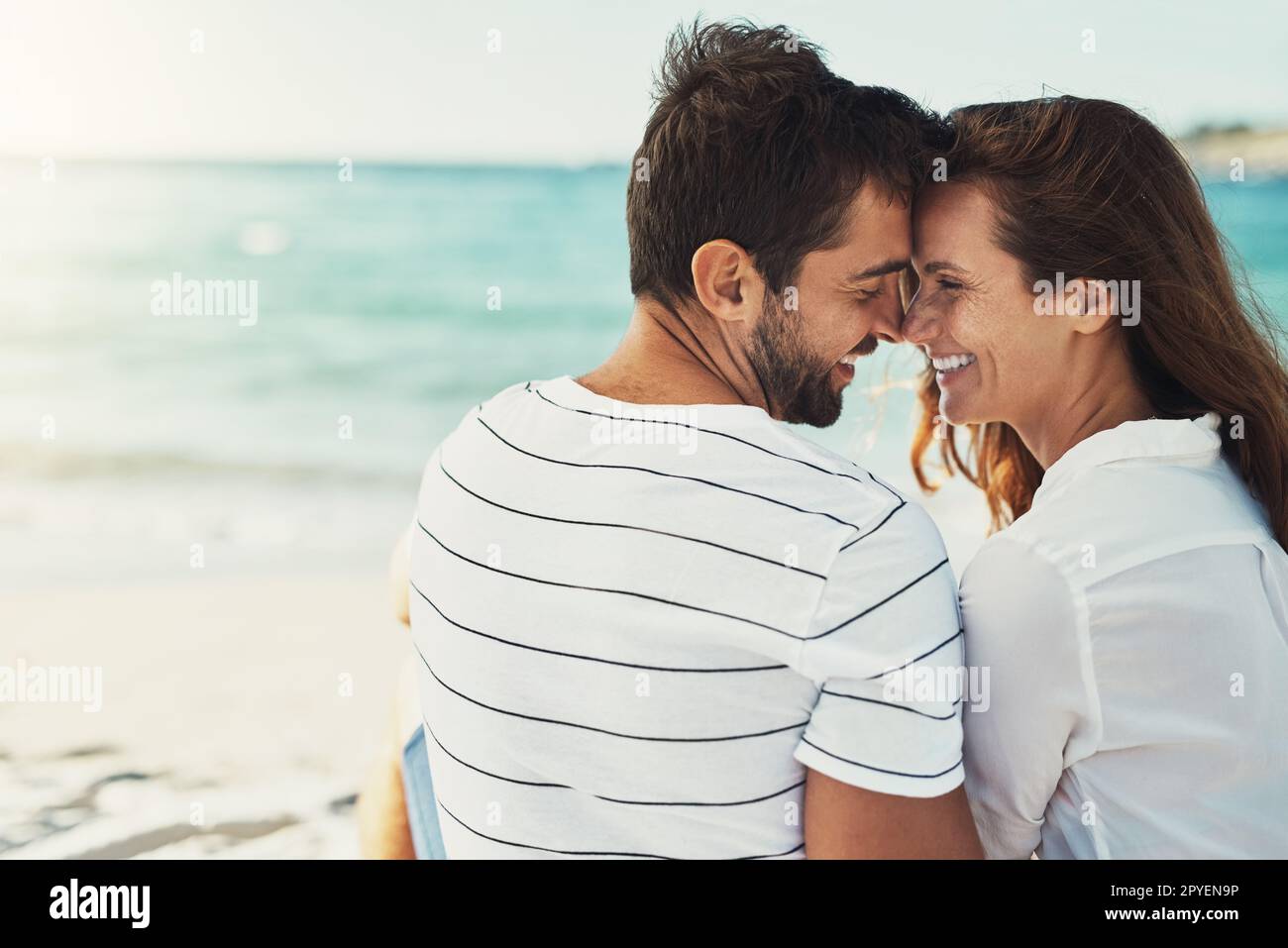 Küsse für einen Sommertraum. Rückblick auf ein junges Paar, das sich an einem Sommertag am Strand küsst. Stockfoto