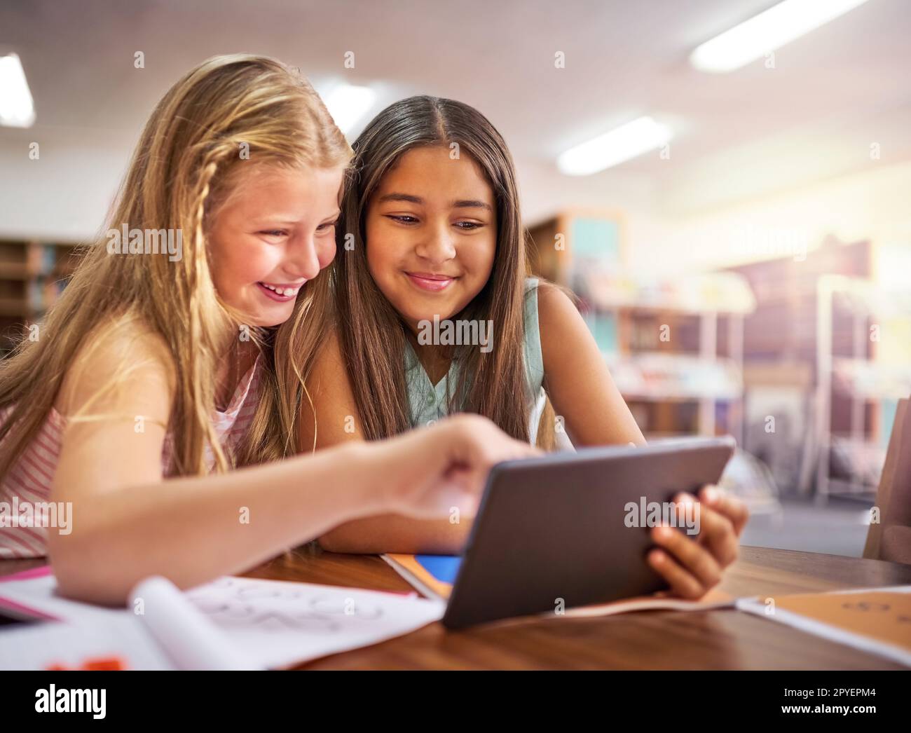 Verbesserung des Lernerlebnisses. Zwei junge Mädchen, die in der Schule ein digitales Tablet benutzen. Stockfoto