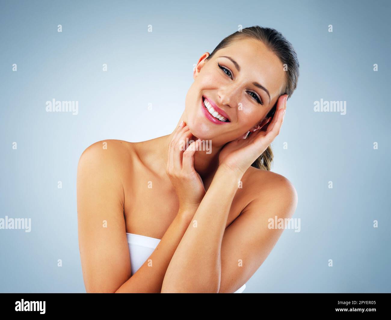 Liebe dich genug, um deine Haut zu pflegen. Studioaufnahme einer schönen und gesunden jungen Frau vor blauem Hintergrund. Stockfoto