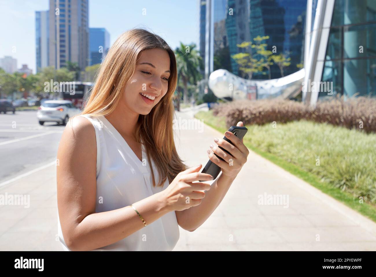 Geschäftsfrau, die Telefongespräche im Finanzdistrikt von Sao Paulo, Brasilien, überprüft Stockfoto