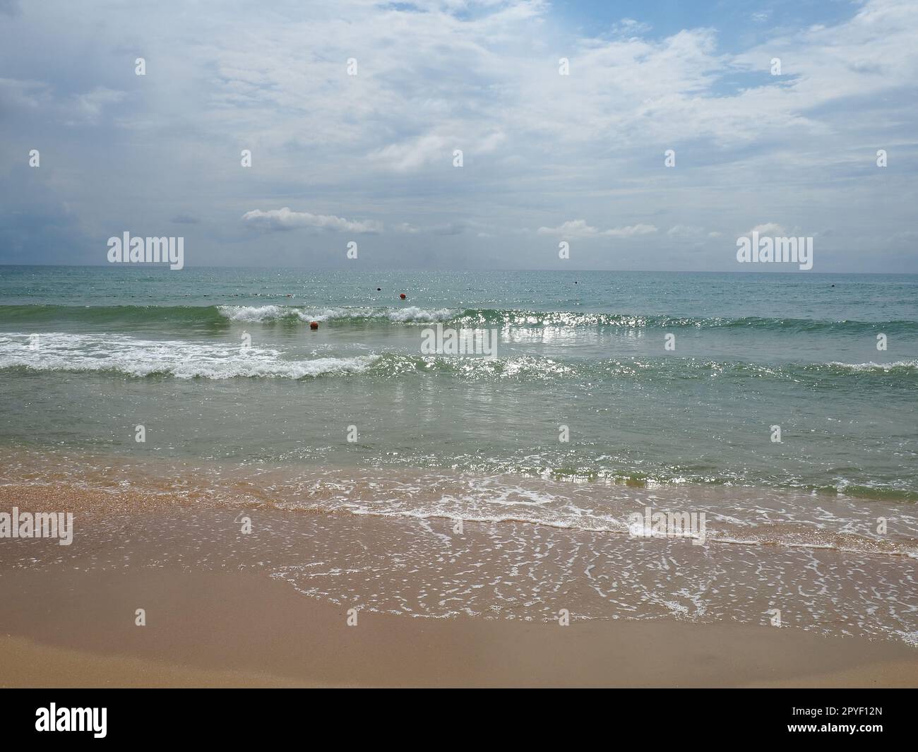 Sommermeer mit glatten Wellen, blauem Himmel, Sand und freiem Platz. Sanfte blaue Meereswelle oder klares Meer am sauberen Sandstrand Sommerkonzept. Traumhafte Strandlandschaft. Schaum auf Meerwasser Stockfoto