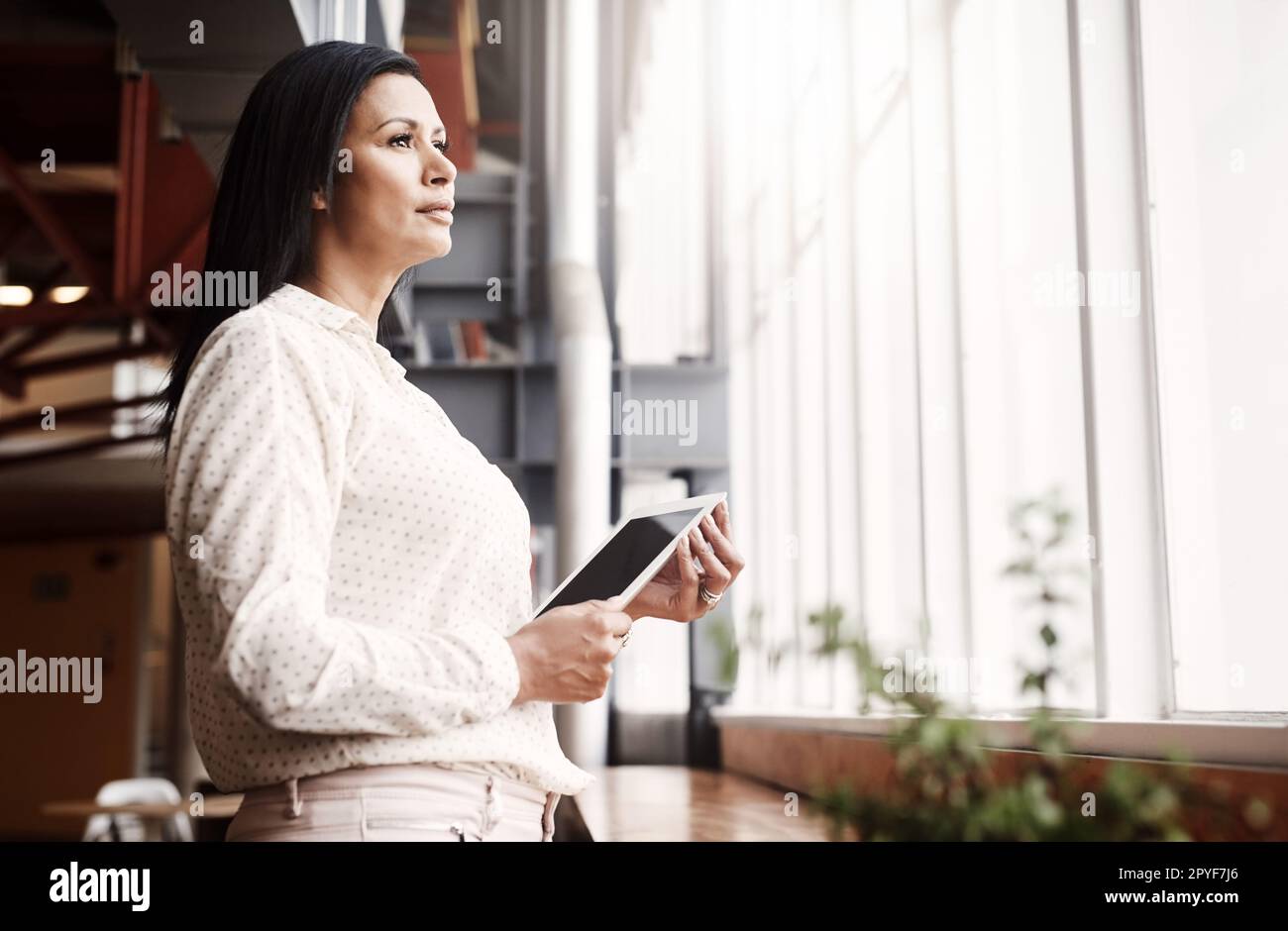 Der Erfolg liegt direkt vor uns. Eine reife Geschäftsfrau, die ein digitales Tablet in einem Büro verwendet. Stockfoto