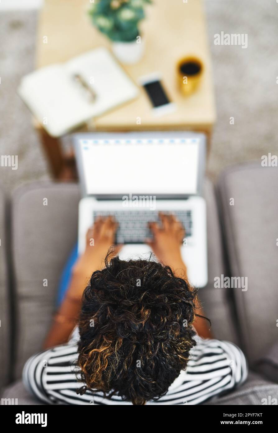 Surfen Sie mit einer Taste nach der anderen im Internet. Eine nicht wiedererkennbare Frau, die von zu Hause aus arbeitet. Stockfoto