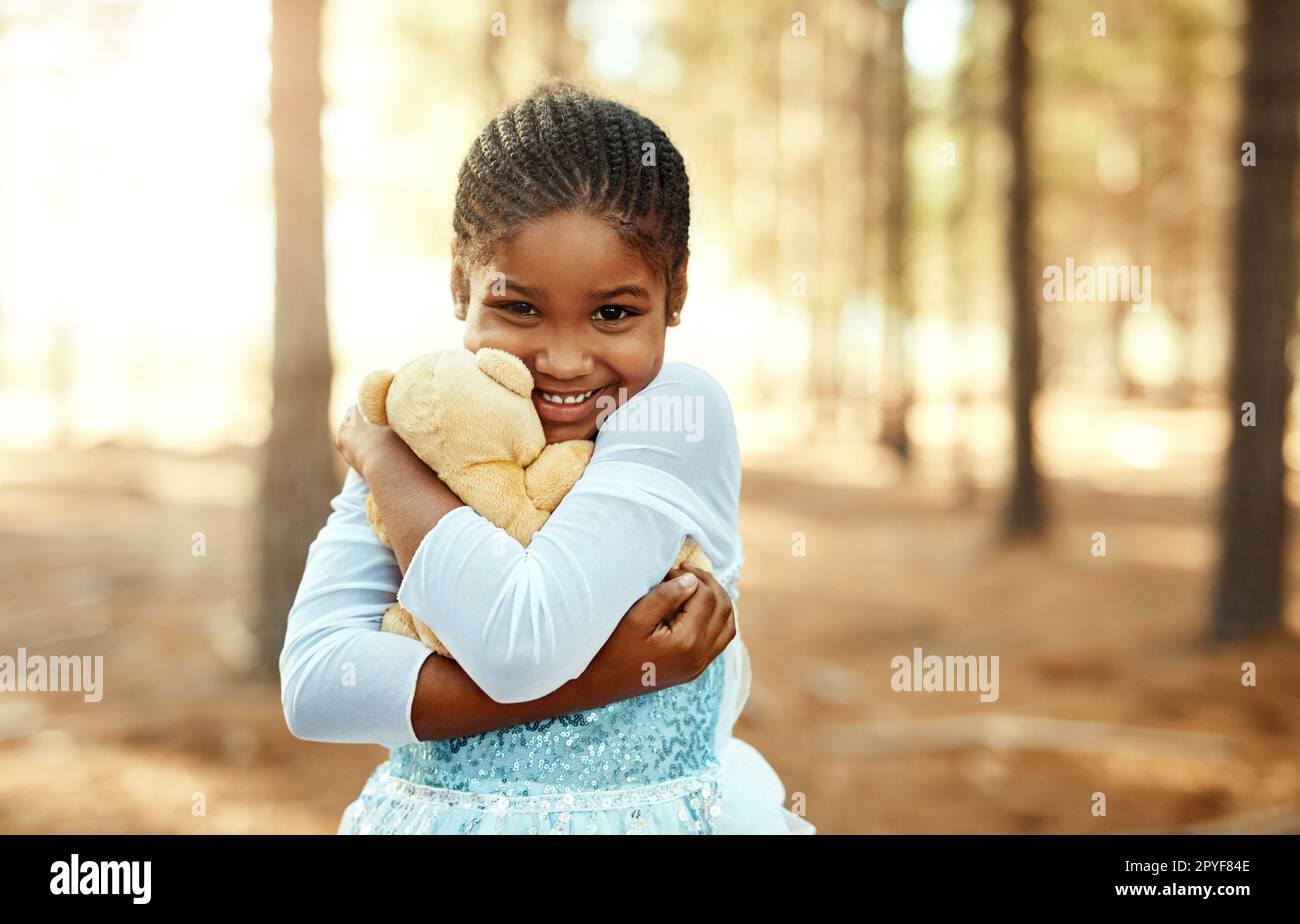 Kinder sind wirklich so bezaubernd. Porträt eines kleinen Mädchens, das mit ihrem Teddybär im Wald spielt. Stockfoto