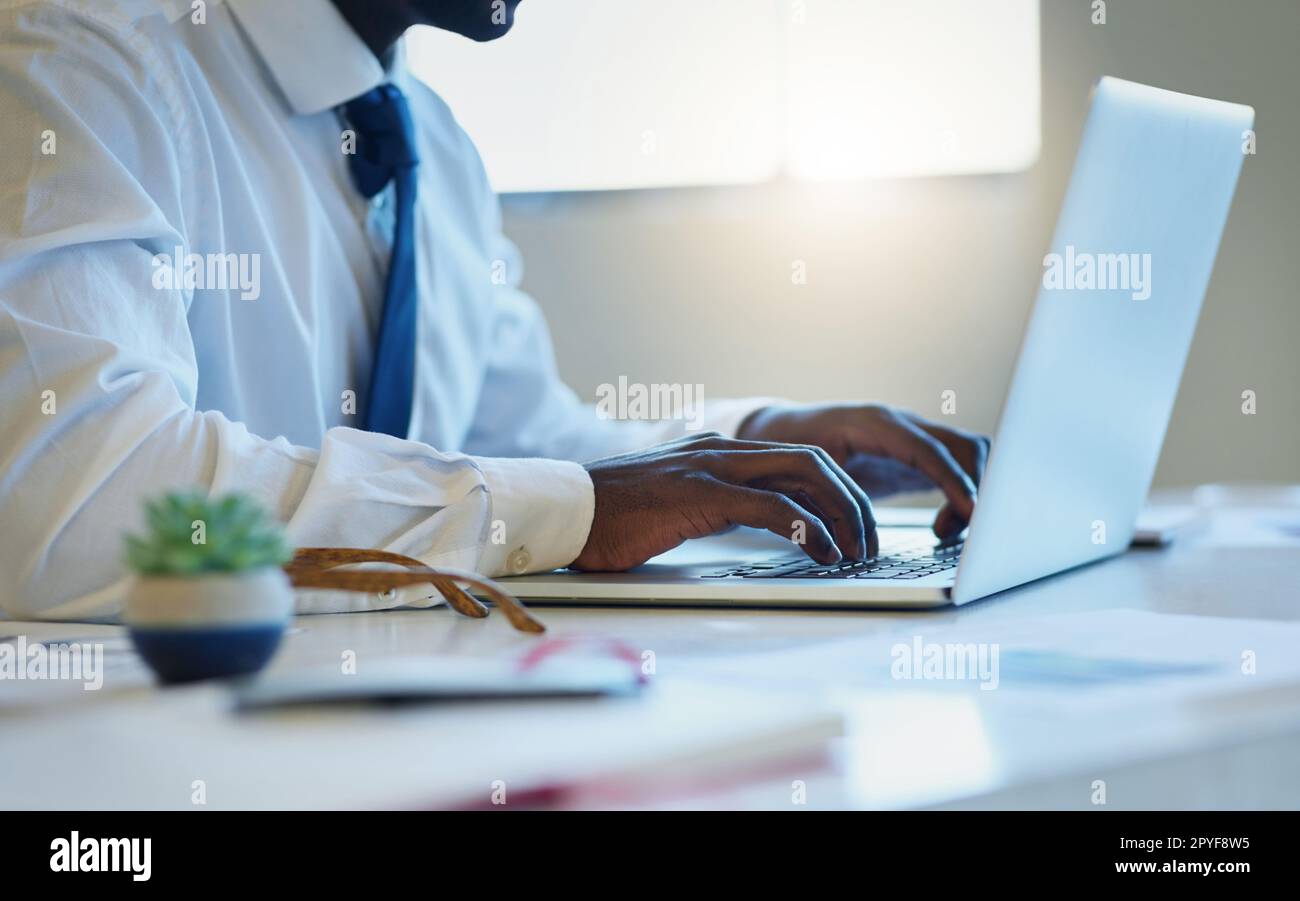Wir kommen dem Erfolg näher. Ein unbekannter Geschäftsmann, der in einem Büro an einem Laptop arbeitet. Stockfoto